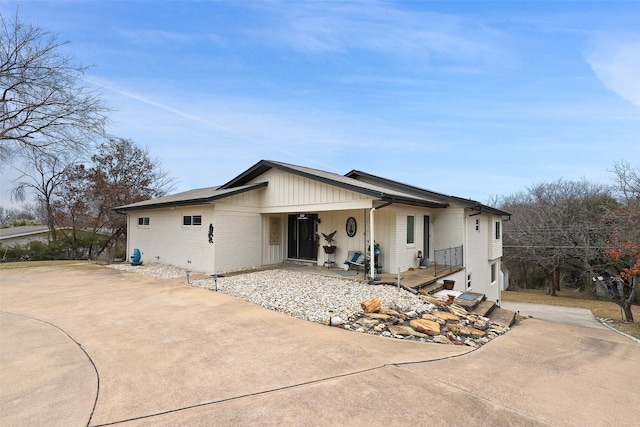 view of front of house featuring brick siding and concrete driveway