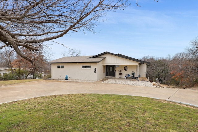 exterior space with brick siding, a yard, a shingled roof, and curved driveway