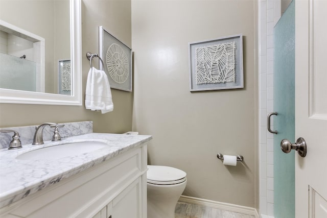 bathroom with toilet, walk in shower, and vanity