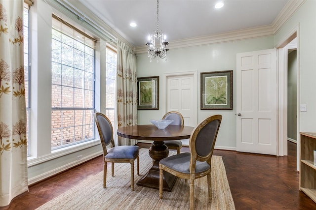 dining area featuring dark parquet flooring, an inviting chandelier, and crown molding