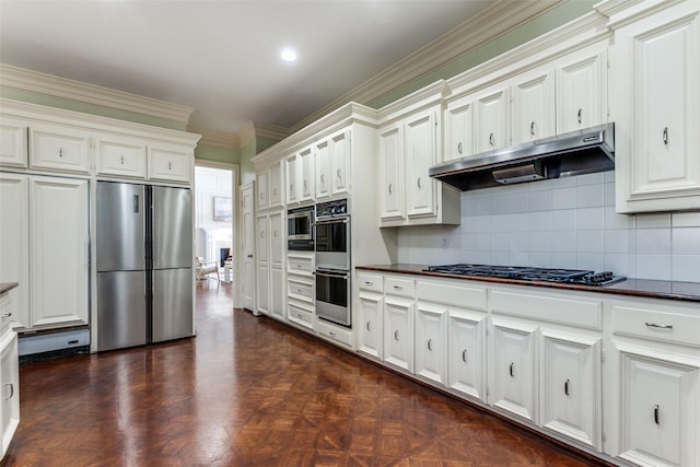 kitchen with tasteful backsplash, white cabinets, appliances with stainless steel finishes, ornamental molding, and dark parquet floors