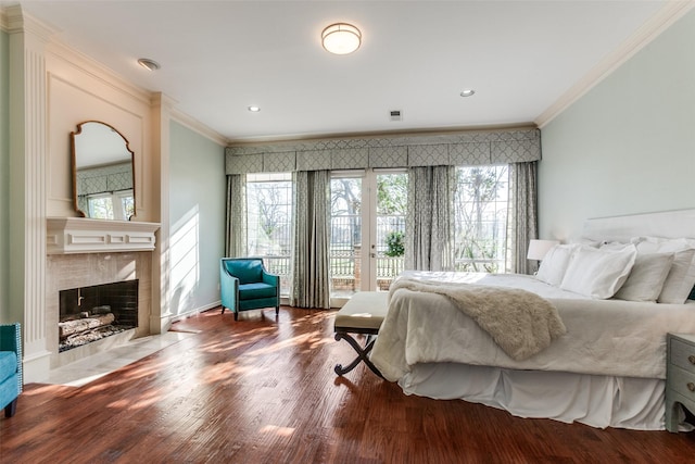 bedroom featuring a high end fireplace, wood-type flooring, ornamental molding, and access to outside