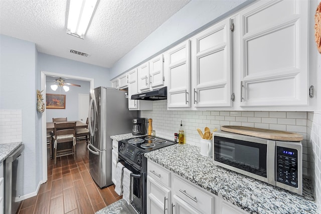 kitchen with light stone countertops, a textured ceiling, stainless steel appliances, white cabinetry, and ceiling fan