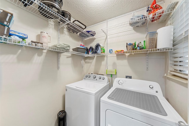 laundry area featuring washing machine and dryer and a textured ceiling