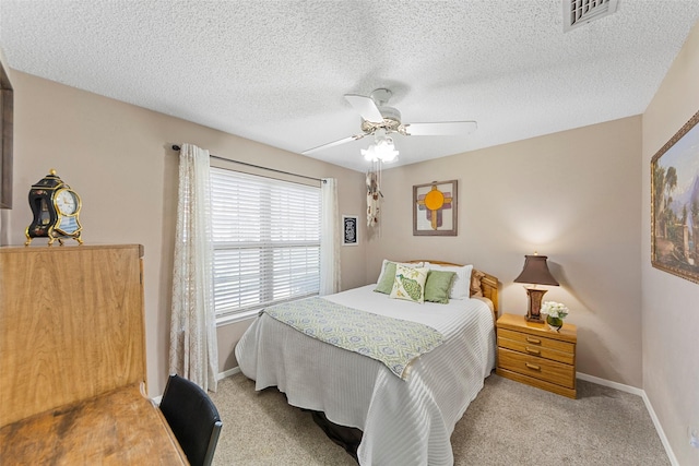 bedroom featuring ceiling fan, light carpet, and a textured ceiling