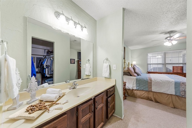 bathroom featuring ceiling fan, a textured ceiling, and vanity