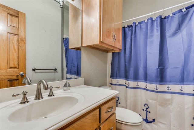 bathroom with toilet, vanity, and walk in shower