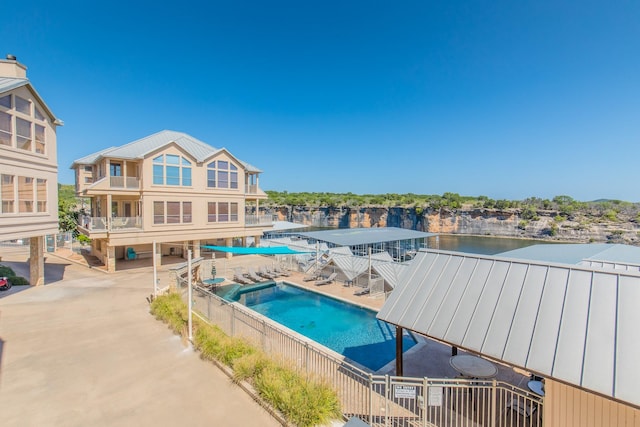 view of swimming pool with a patio and a water view