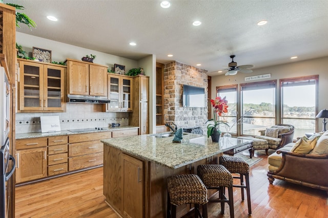 kitchen with sink, a breakfast bar area, a center island, and light wood-type flooring