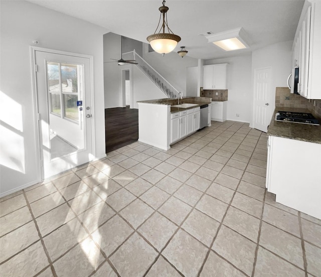 kitchen with hanging light fixtures, stainless steel appliances, tasteful backsplash, white cabinetry, and sink