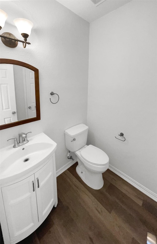 bathroom featuring toilet, vanity, and hardwood / wood-style flooring