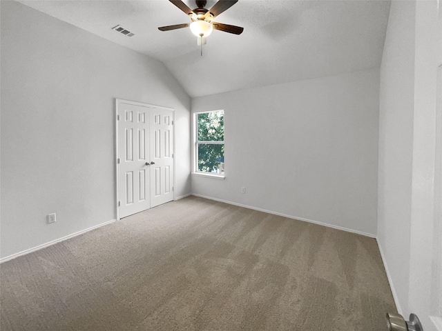 interior space with lofted ceiling, carpet flooring, and ceiling fan