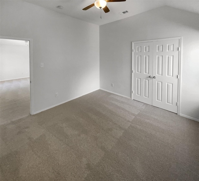 spare room featuring ceiling fan, vaulted ceiling, and carpet flooring