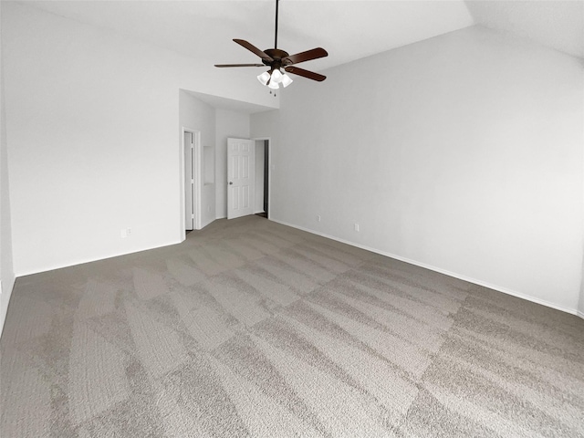 empty room featuring ceiling fan, vaulted ceiling, and carpet flooring