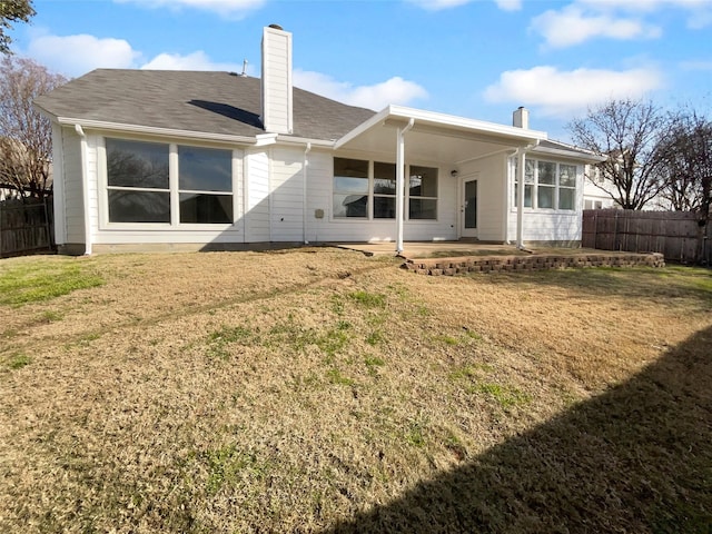 back of house with a patio area and a lawn