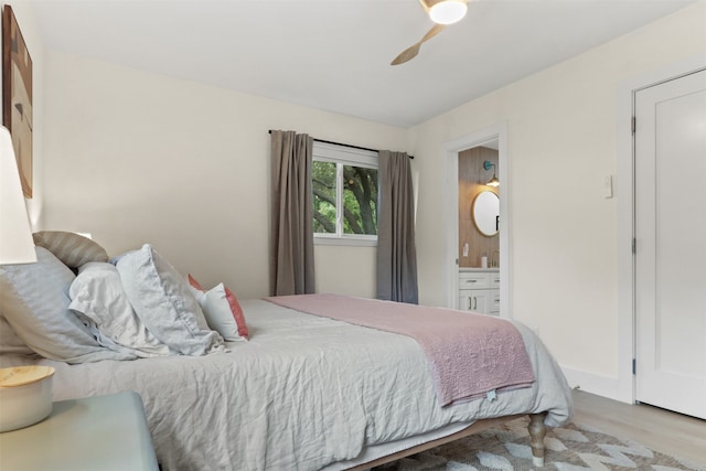 bedroom with ensuite bath, ceiling fan, and light hardwood / wood-style floors