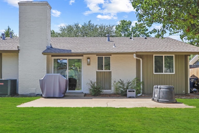 rear view of property featuring a patio, central AC unit, and a lawn