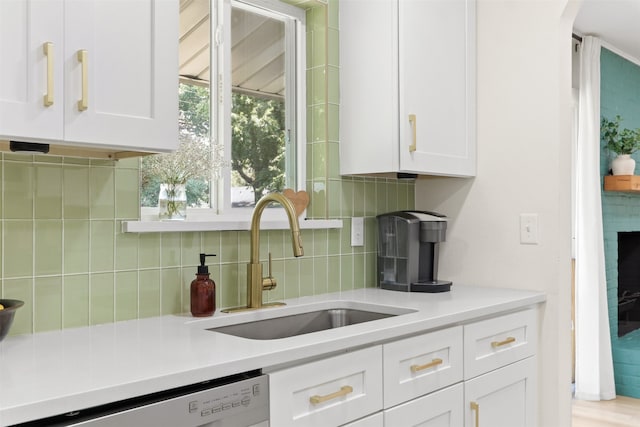 kitchen with sink, white cabinets, tasteful backsplash, and dishwasher