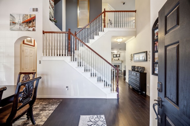 foyer entrance featuring a towering ceiling and dark hardwood / wood-style floors