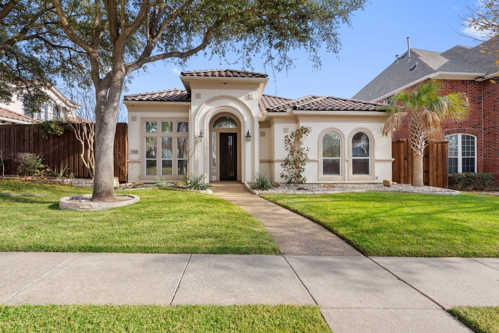 mediterranean / spanish home featuring a front lawn