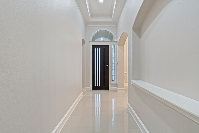 interior space featuring a towering ceiling, light tile patterned flooring, and crown molding