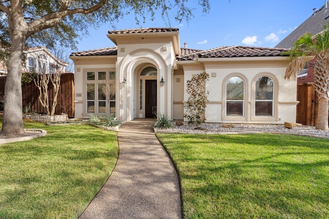 mediterranean / spanish-style home featuring french doors and a front lawn