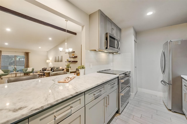 kitchen with stainless steel appliances, decorative light fixtures, gray cabinets, decorative backsplash, and light stone countertops