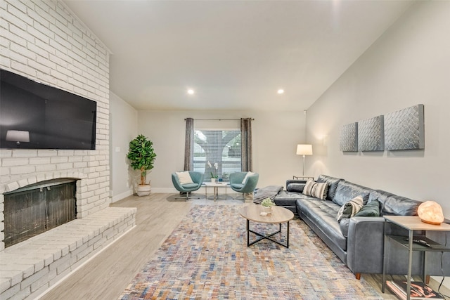 living room with a brick fireplace and light hardwood / wood-style floors