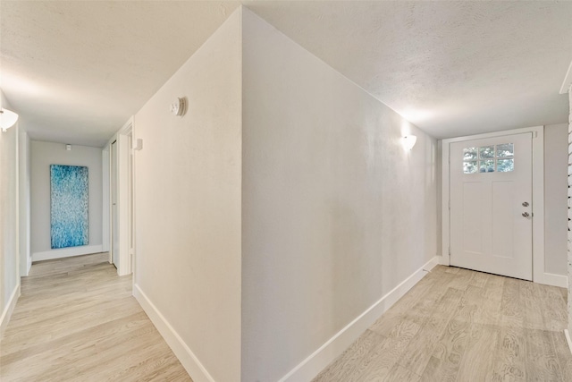 foyer with a textured ceiling and light hardwood / wood-style floors