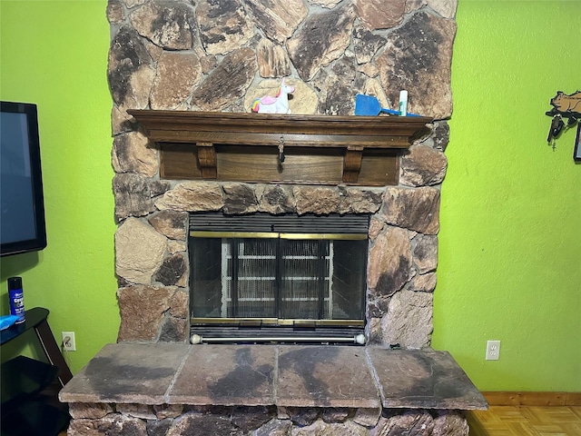 room details featuring parquet flooring and a stone fireplace