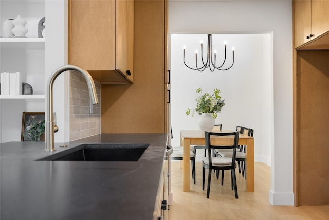 kitchen with a notable chandelier, stainless steel electric range oven, decorative backsplash, wall chimney range hood, and light hardwood / wood-style flooring