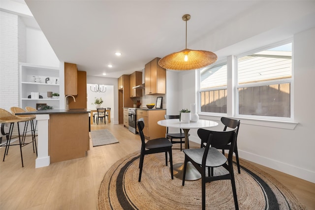 living room featuring a fireplace, light hardwood / wood-style flooring, and a towering ceiling