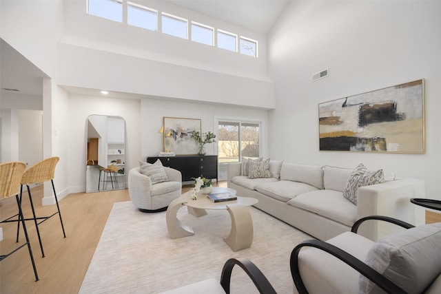 living room with a high ceiling and light wood-type flooring