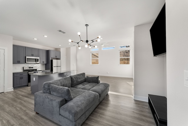 living room featuring wood-type flooring and a chandelier