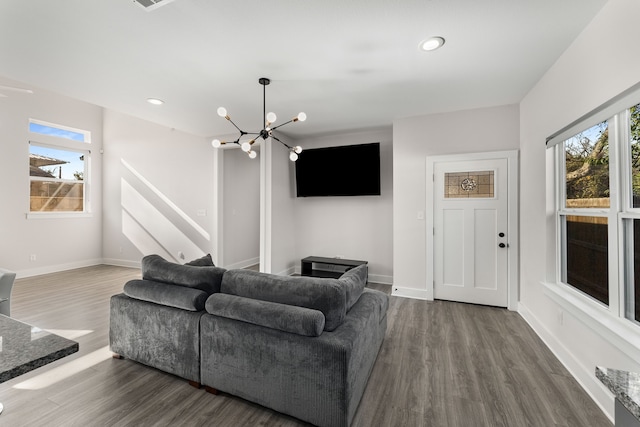 living room with wood-type flooring, a chandelier, and a wealth of natural light