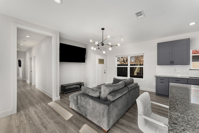 living room with a notable chandelier and dark hardwood / wood-style floors