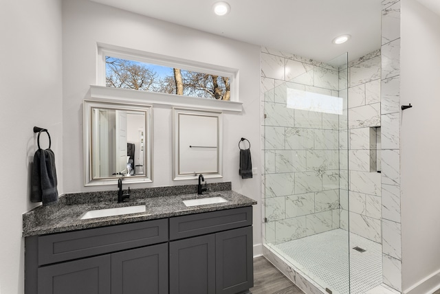 bathroom featuring a tile shower, vanity, and hardwood / wood-style floors