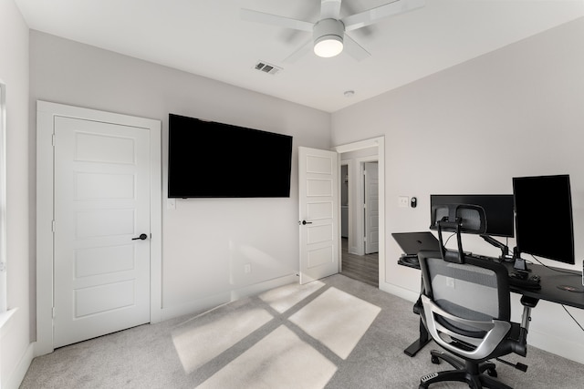 home office featuring light carpet and ceiling fan