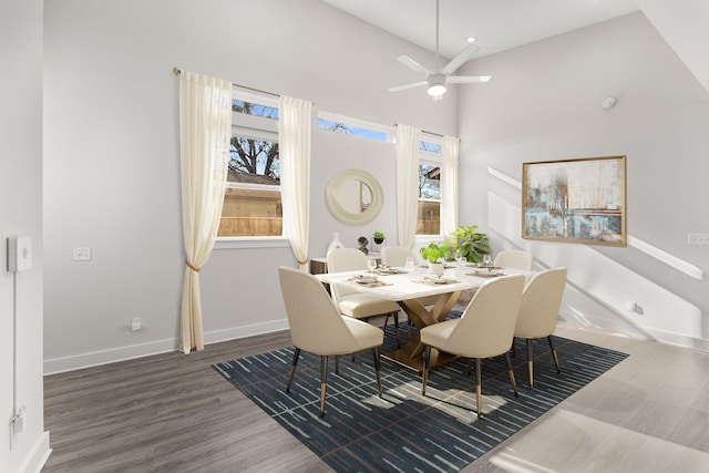 dining room featuring dark wood-type flooring, high vaulted ceiling, and ceiling fan