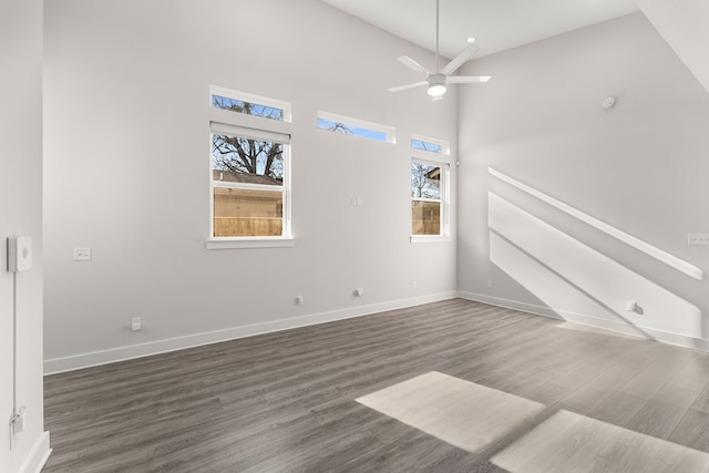 unfurnished living room featuring dark wood-type flooring, high vaulted ceiling, and ceiling fan