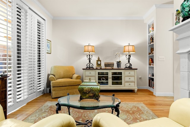 living area featuring built in shelves, light wood-type flooring, and ornamental molding