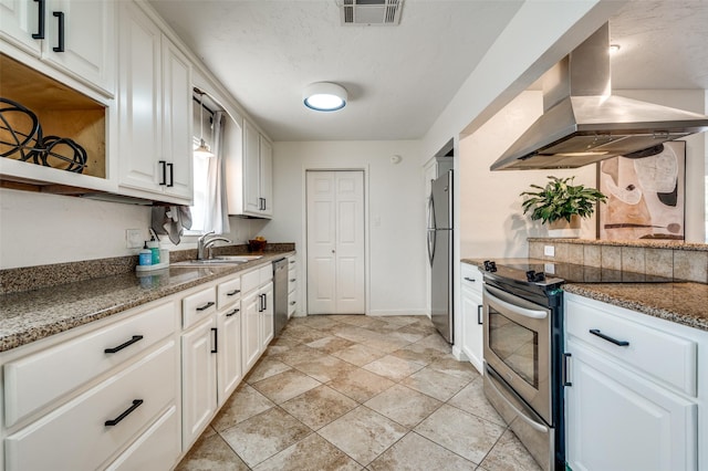 kitchen featuring stainless steel appliances, dark stone countertops, white cabinets, and island range hood