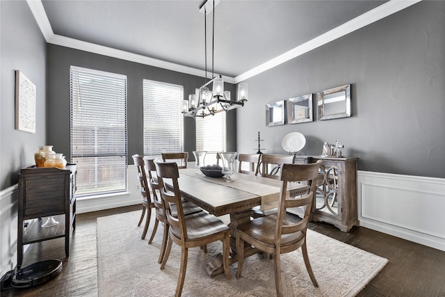 dining room with a notable chandelier, crown molding, and dark hardwood / wood-style flooring