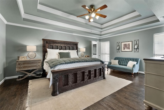 bedroom with dark hardwood / wood-style flooring, ceiling fan, a tray ceiling, and crown molding