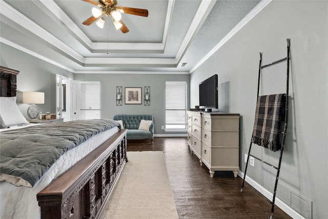 bedroom featuring ceiling fan, multiple windows, a raised ceiling, and dark hardwood / wood-style floors