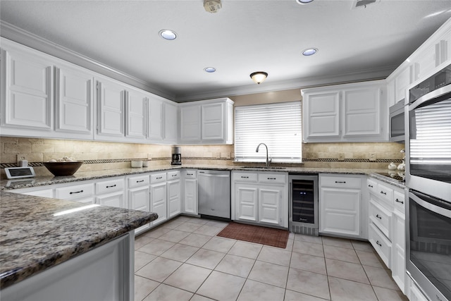 kitchen featuring wine cooler, appliances with stainless steel finishes, light tile patterned floors, sink, and white cabinetry