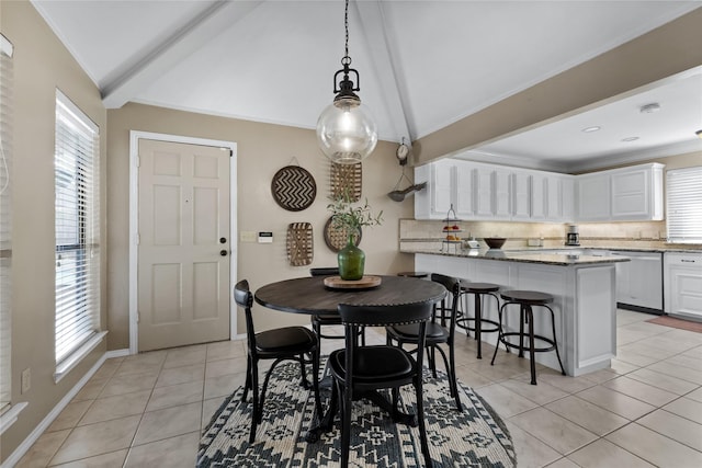 tiled dining space with lofted ceiling with beams and a wealth of natural light