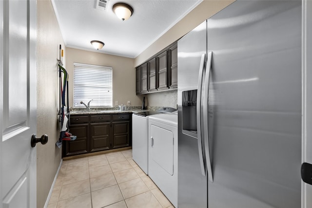 clothes washing area with sink, cabinets, independent washer and dryer, light tile patterned floors, and crown molding