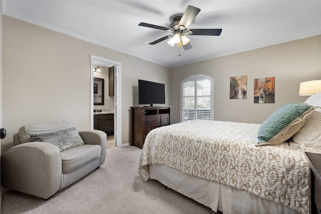 bedroom with ceiling fan, light colored carpet, ornamental molding, and ensuite bath