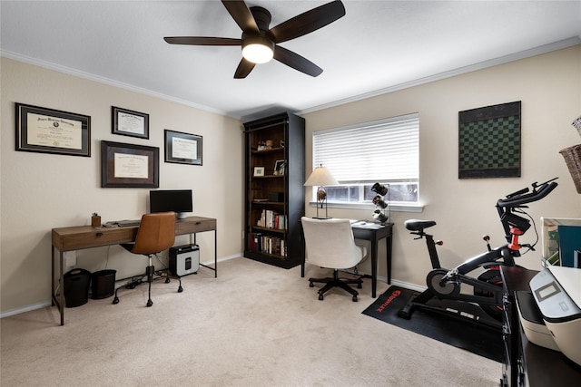 carpeted home office featuring ceiling fan and crown molding